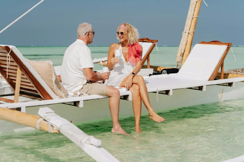 Elderly couple on a dhow enjoying a sunny beach day after successfully  escaping the pension trap.