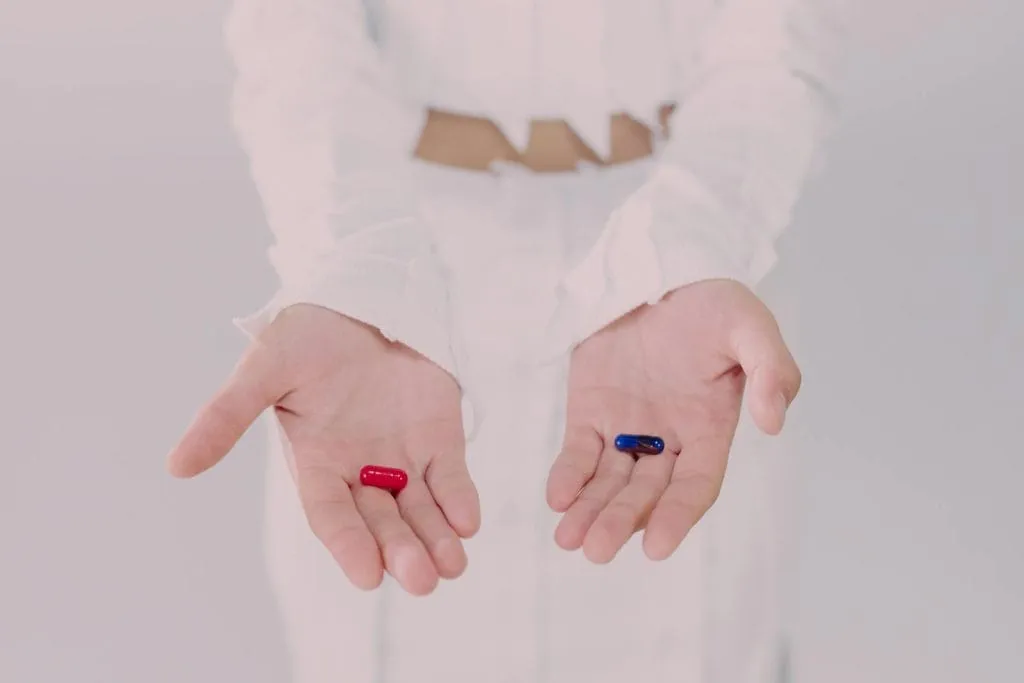 Close-up of hands holding red and blue pills, symbolizing the choice of leveraging corporate skills.